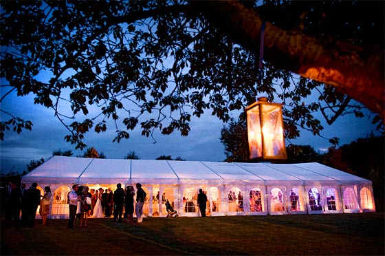 Milling around a wedding marquee at dusk