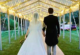 Bride and groom approach their wedding party via an extra-long walkway