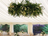 Wedding marquee with opulent floral ring hanging from the roof, Barnes